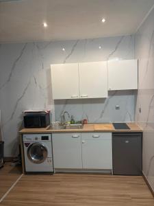 a kitchen with white cabinets and a washing machine at Appart 4 personnes in Lille