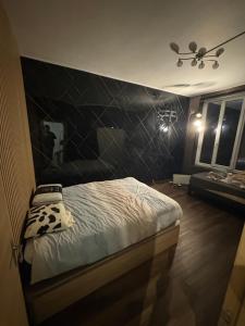 a bedroom with a bed with a black wall at Appart 4 personnes in Lille