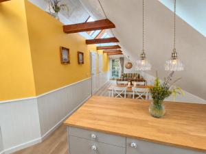 a kitchen with yellow walls and a vase of flowers on a counter at Villa Vendel B&B in Løkken