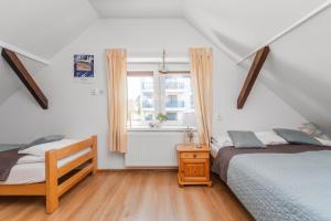 a bedroom with two beds and a window at Jantar, dom blisko plaży z sauną in Jantar