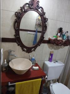 a bathroom with a sink and a mirror and a toilet at El Camino in Gardey +25 photos