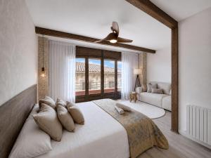 a bedroom with a large bed with a ceiling fan at Apartamento Ca Blai de Brull en el centro de Tivissa in Tivissa