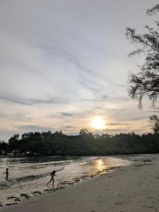 two people playing on the beach at sunset at Shareen Homestay Morib in Banting