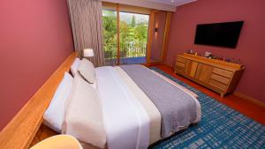 a bedroom with a large bed and a television at Viscas Hotel Luxury Resort & Spa in Pariahuanca