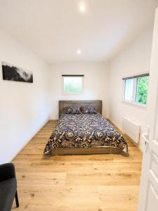 a bedroom with a bed in a white room at Chez Julia in Brech