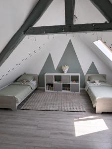 two beds in a attic room with mountains painted on the wall at Gite a la ferme in Courcelles-les-Lens