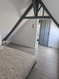 a bedroom with a bed and a wooden floor at Gite a la ferme in Courcelles-les-Lens