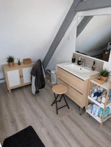 a bathroom with a sink and a mirror and a stool at Gite a la ferme in Courcelles-les-Lens