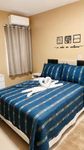 a bed with a blue and white striped blanket at River Suites Hotel Barreirinhas in Barreirinhas
