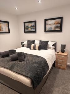 a bedroom with a large bed and a night stand at Abbys Cottage in Windermere