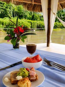 a table with a plate of food and a drink at Lagoon Village B&B y SPA in Tarapoto