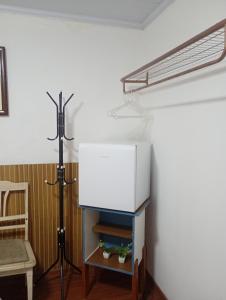 a white refrigerator in a room with a tripod at Dexa Hospedagem in Ouro Preto