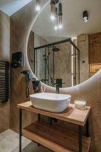 a bathroom with a sink and a mirror at Willa Regina I Resort & SPA in Zakopane
