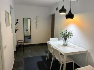 a dining room with a white table and chairs at Marc Apartament in Turda