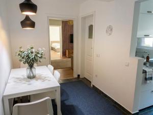a kitchen and dining room with a white table and chairs at Marc Apartament in Turda