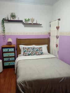 a bedroom with a bed and a purple wall at Dexa Hospedagem in Ouro Preto +12 photos