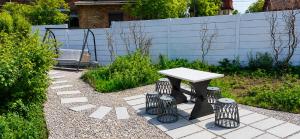 a table and stools in a garden with a bench at Fairy- tale house in Przeróbka in Gdańsk