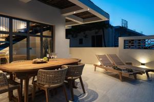 a patio with a wooden table and chairs at Capo Davia seaside Villa in Argassi