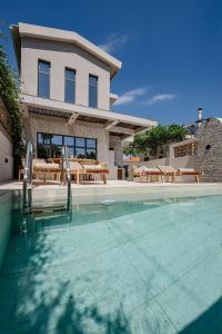 a house with a swimming pool in front of a house at Capo Davia seaside Villa in Argassi