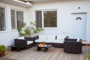 un patio con un sofá blanco y una mesa en Engels Landhaus Suite, en Mörbisch am See