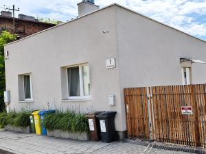 a white house with trash cans and a fence at Fairy- tale house in Przeróbka in Gdańsk +1 photo