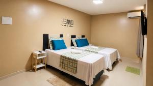 a bedroom with two beds with blue pillows at River Suites Hotel Barreirinhas in Barreirinhas +6 photos