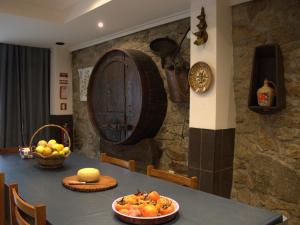a table with a plate of fruit and a barrel at Casajurada in Pinhel