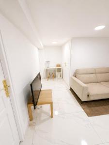 a living room with a couch and a tv at EDEN SUITE Escale proche de CDG in Tremblay-En-France