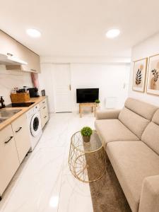 a living room with a couch and a kitchen at EDEN SUITE Escale proche de CDG in Tremblay-En-France +4 photos