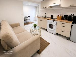 a living room with a couch and a kitchen at EDEN SUITE Escale proche de CDG in Tremblay-En-France