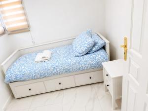 a small bedroom with a bed with blue sheets at EDEN SUITE Escale proche de CDG in Tremblay-En-France