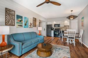 a living room with a blue couch and a table at Coconut Palms Beach Resort II, an Ascend Collection Hotel in New Smyrna Beach