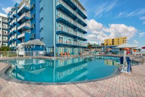 a swimming pool in front of a building at Coconut Palms Beach Resort II, an Ascend Collection Hotel in New Smyrna Beach