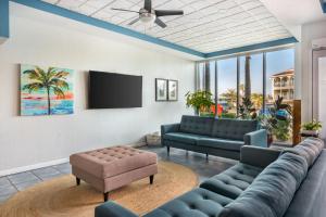 a living room with blue couches and a flat screen tv at Coconut Palms Beach Resort II, an Ascend Collection Hotel in New Smyrna Beach
