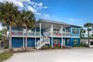 a blue house with palm trees in front of it at Coconut Palms Beach Resort II, an Ascend Collection Hotel in New Smyrna Beach