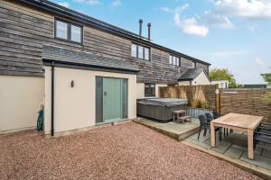 a backyard of a house with a grill and a table at Bell House in Amlwch
