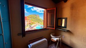 a bathroom with a window with a view of a beach at La Rosa dei venti in Nebida