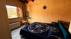 a bedroom with a bed with blue sheets and a window at La Rosa dei venti in Nebida +20 photos