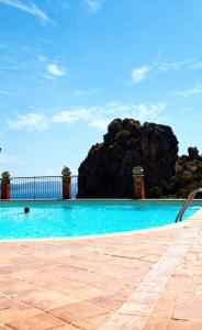 a swimming pool with a mountain in the background at La Rosa dei venti in Nebida