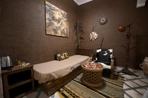 a bedroom with a bed and a chair in it at Riad MISS CARACAL Jacuzzi & Rooftop in Marrakesh
