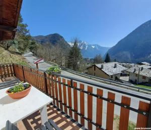 a table on a balcony with a view of a mountain at Villetta Col Ranzola in Brusson +4 photos