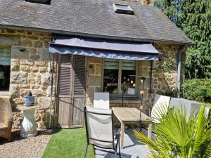 a patio with a table and chairs in front of a building at Gites Armorique in Plésidy