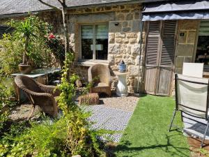 a garden with chairs and a table and a building at Gites Armorique in Plésidy +6 photos