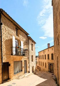an alley in an old building with a balcony at Maison rénovée, centre médiéval de Belvès in Belvès