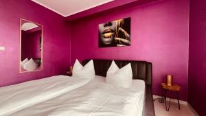 a bedroom with a white bed with purple walls at Apartment Am Paradies in Bad Lauterberg +10 photos