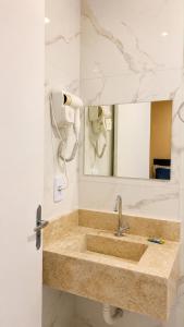 a bathroom with a large sink and a mirror at River Suites Hotel Barreirinhas in Barreirinhas