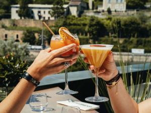 two people holding up drinks on a table at Novotel Lyon Centre-Confluence Bord de Saone in Lyon