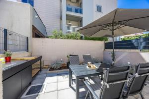 a table and chairs with an umbrella on a patio at Stillar Apartment near sea in Pula