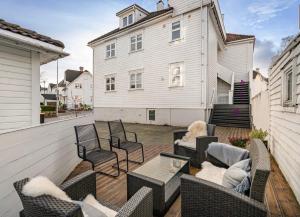 a patio with chairs and a table and a building at Asanzo Historic Attic-Traditional Norwegian Home & Warm Indian Hospitality in Stavanger