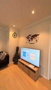 a living room with a large flat screen tv at Asanzo Historic Attic-Traditional Norwegian Home & Warm Indian Hospitality in Stavanger